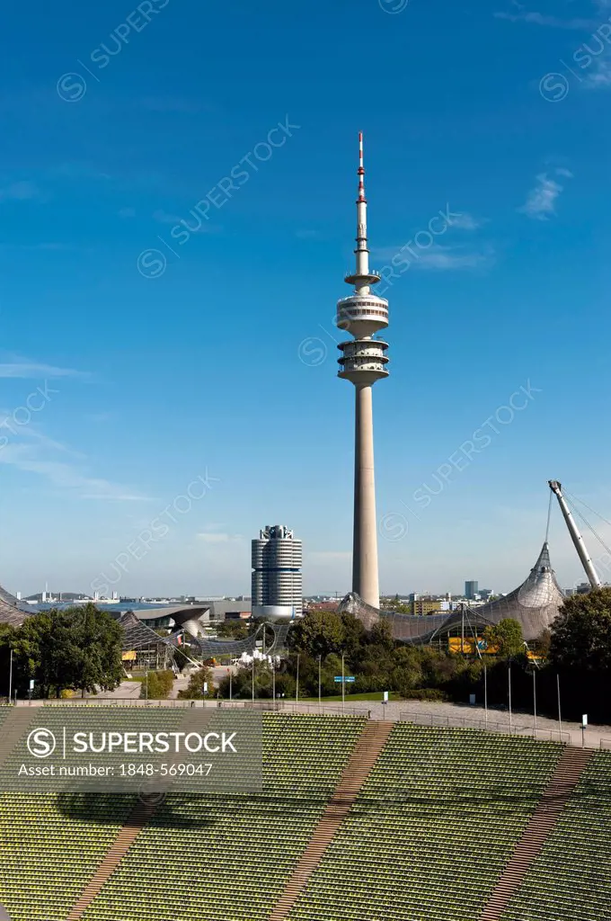 View across the seats of the Munich Olympic stadium towards the TV tower, the BMW headquarters also called four-cylinder building and the BMW World, e...