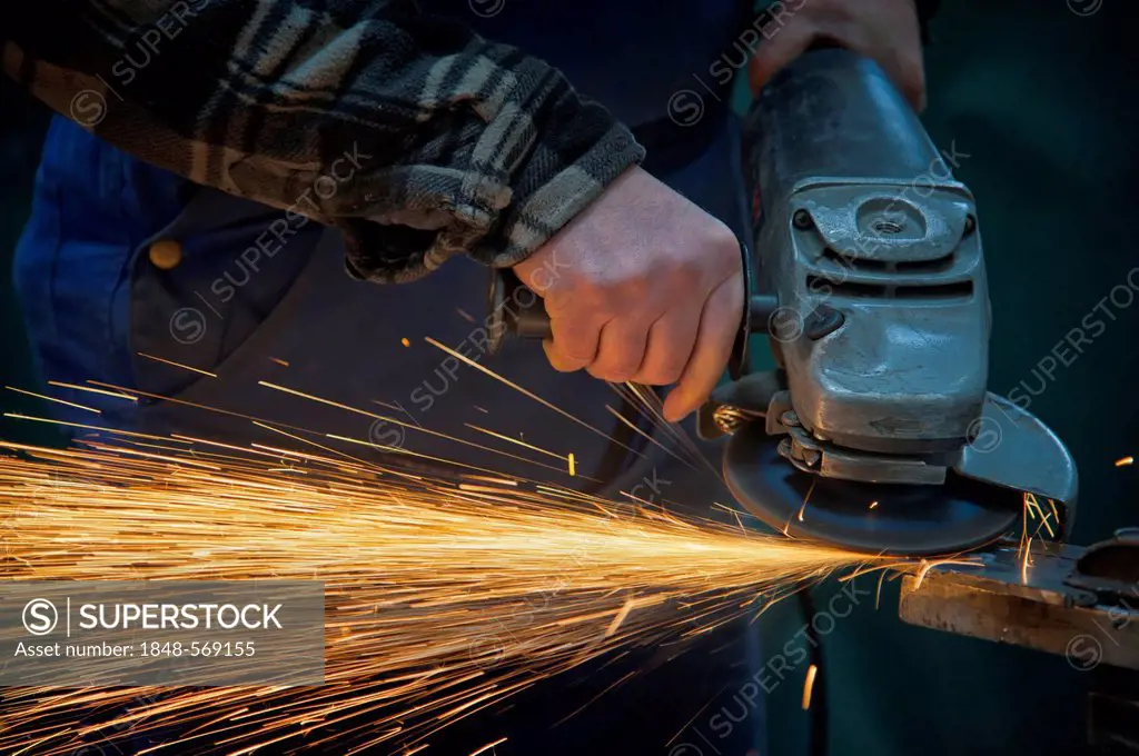 Hands of a worker using an angle grinder