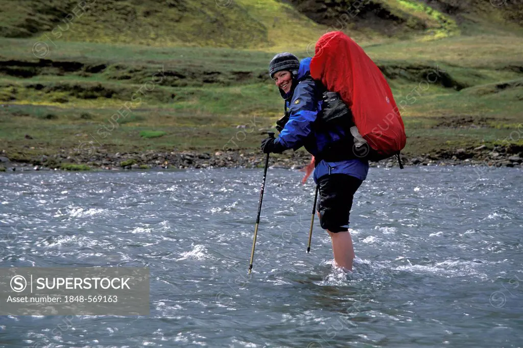 Woman with backpack crossing river, Álftavatn, Laugavegur hiking trail, Fjallabak nature reserve, highland, Iceland, Europe