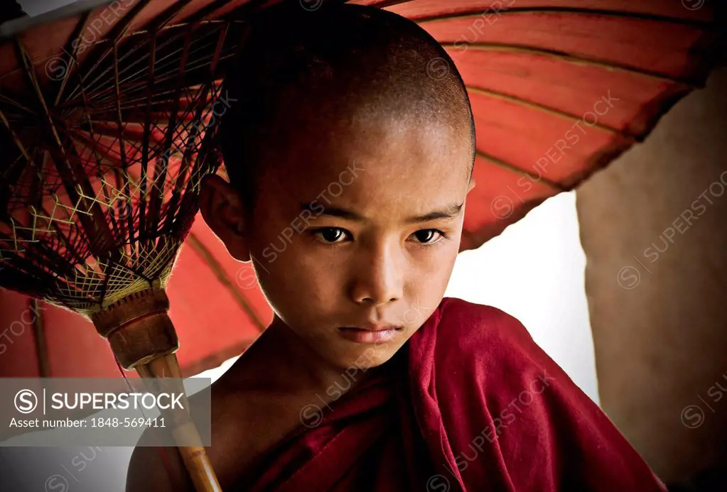 Buddhist novice holding an umbrella, Bagan, Burma, Myanmar, Southeast Asia, Asia