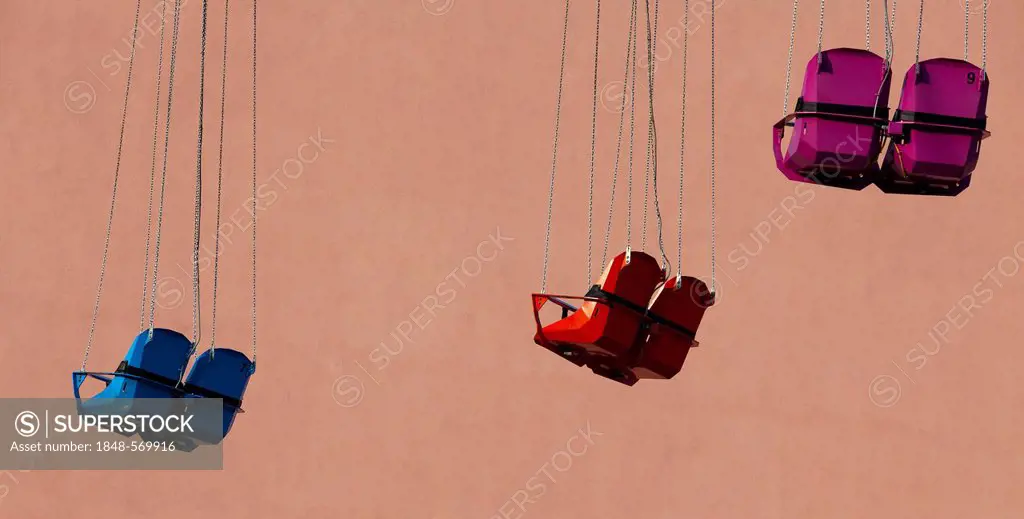 Empty seats of a Chairoplane or swing carousel in front of a house facade, Berlin, Germany, Europe