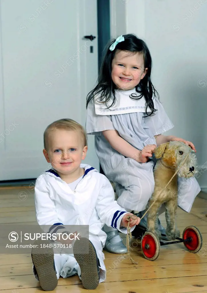 Siblings, boy, 2, and girl, 5, wearing sailor outfits