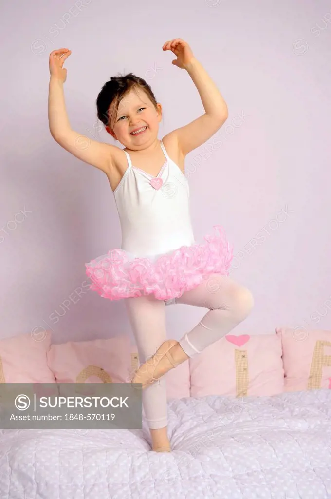 Girl, 5, wearing a ballet outfit on her bed