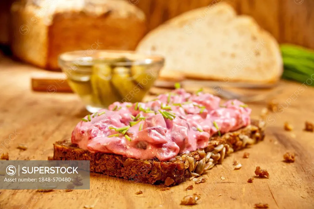 Slice of wholegrain bread with herring salad and chives