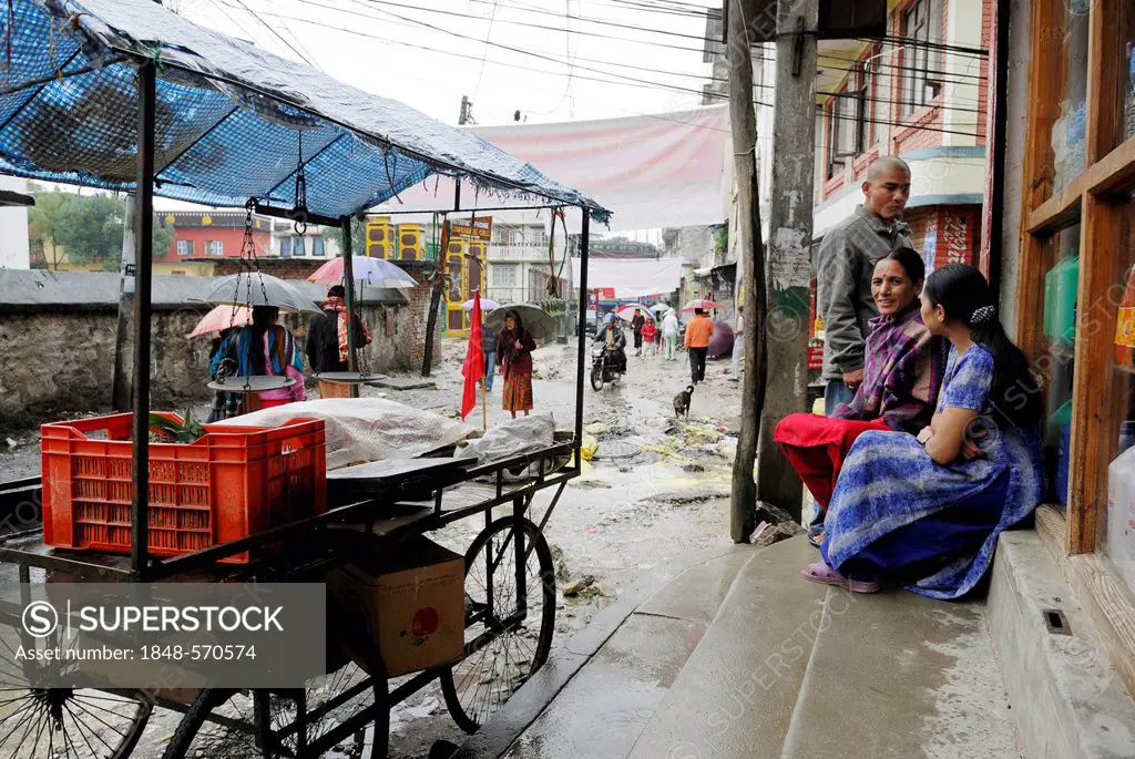 Nepali women in the rain on the streets of Kathmandu, Kathmandu, Nepal, Asia