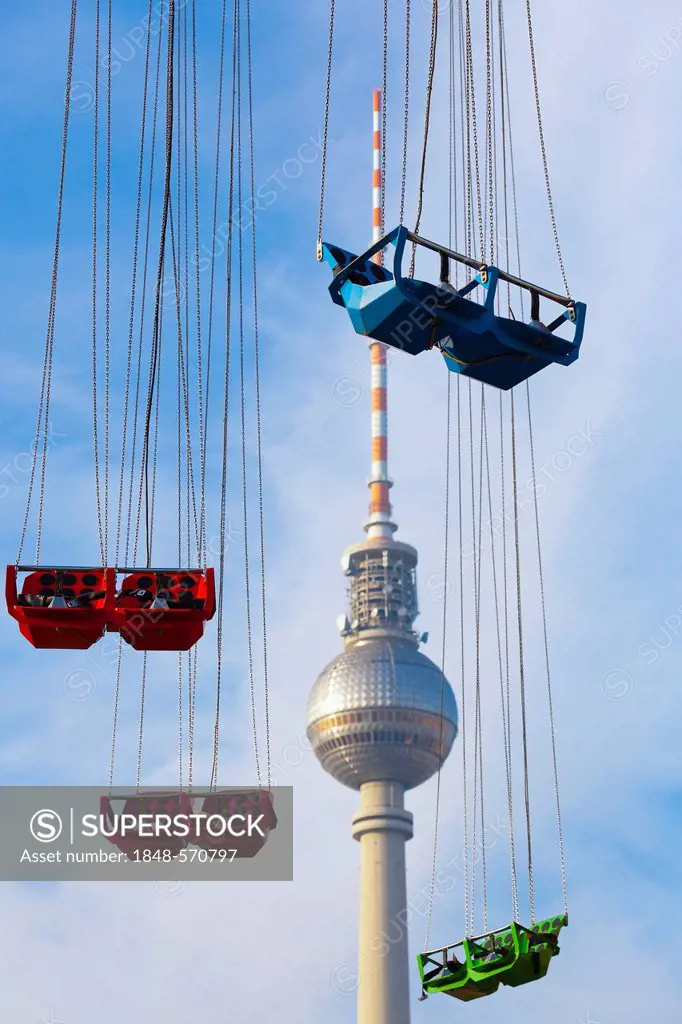 Empty seats of a Chairoplane or swing carousel in front of the Television Tower in Alexanderplatz, Berlin, Germany, Europe