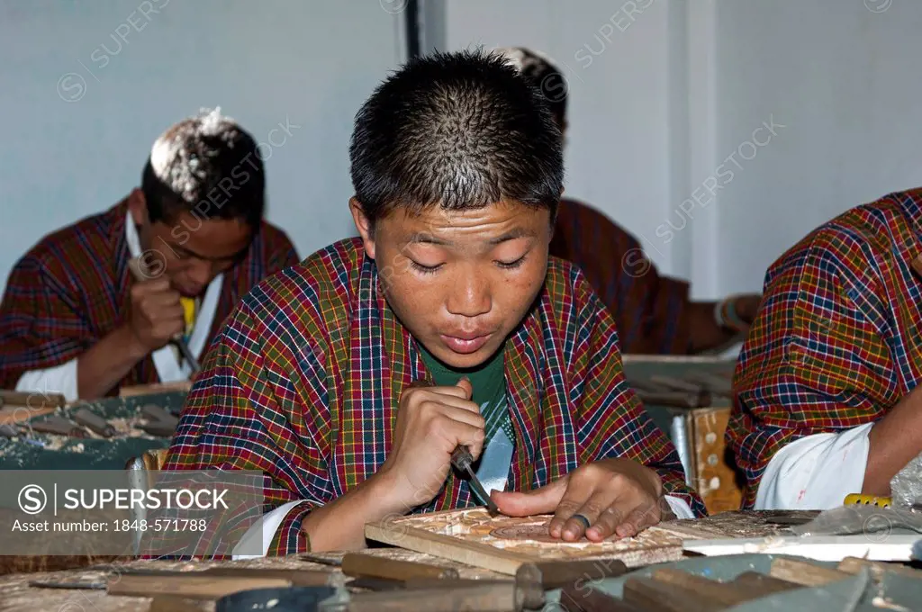 Highly concentrated students doing an apprenticeship in woodcarving at the National Institute of Traditional Arts and Crafts, Zorig Chusum, Thimphu, B...