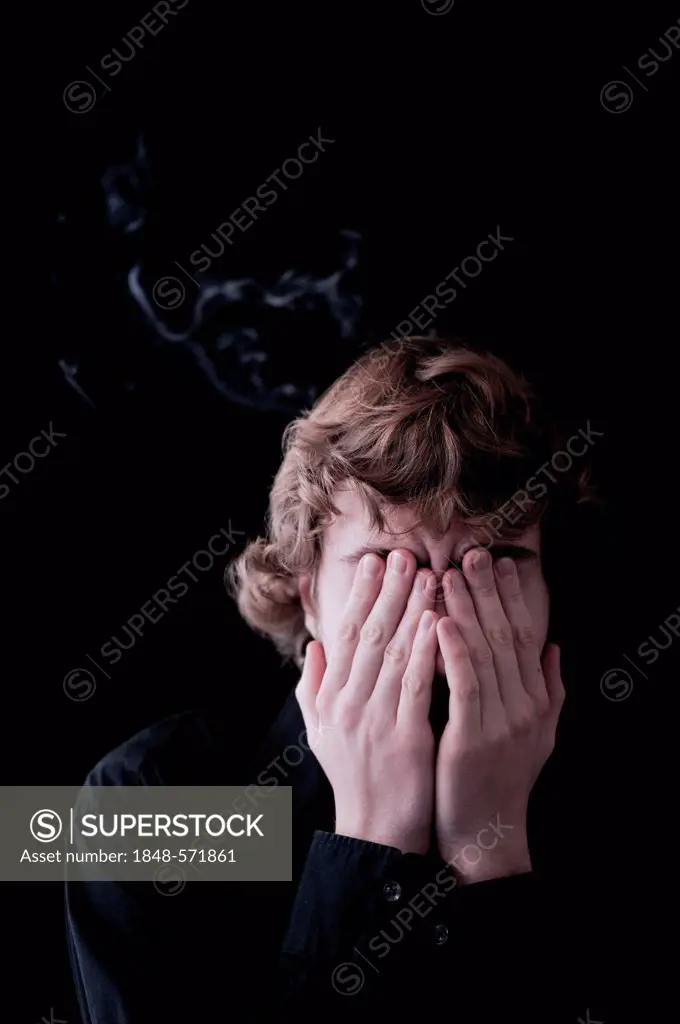 Young man covering face with his hands