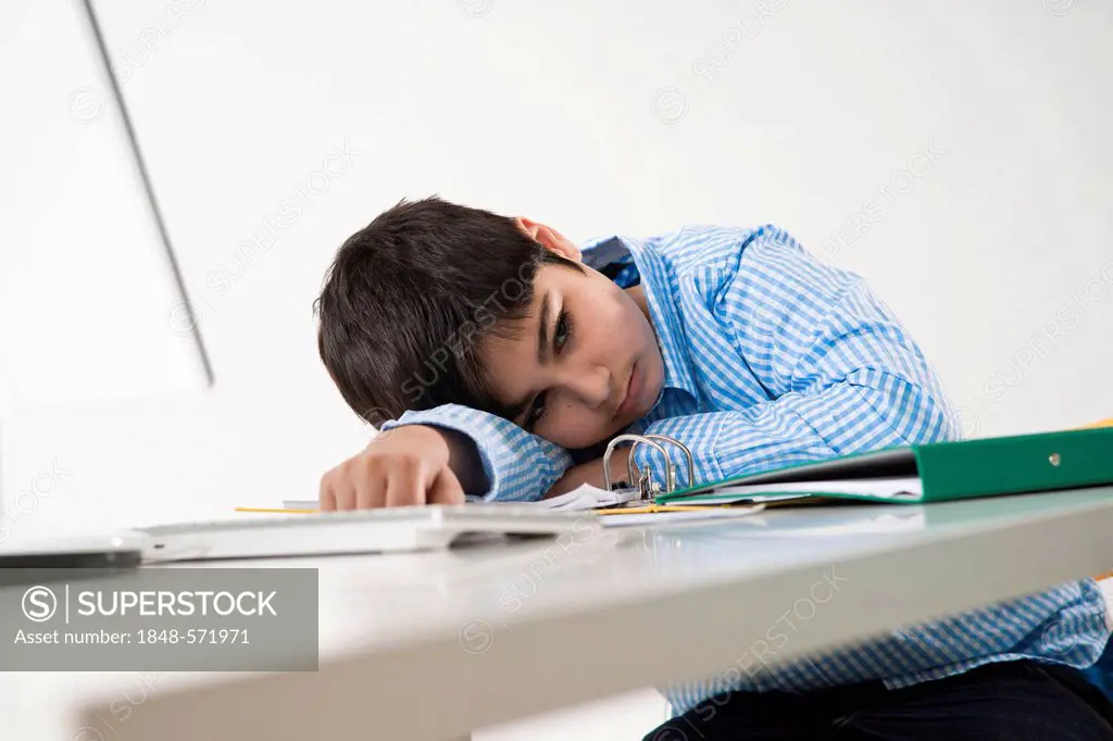 Exhausted boy is sitting at his computer