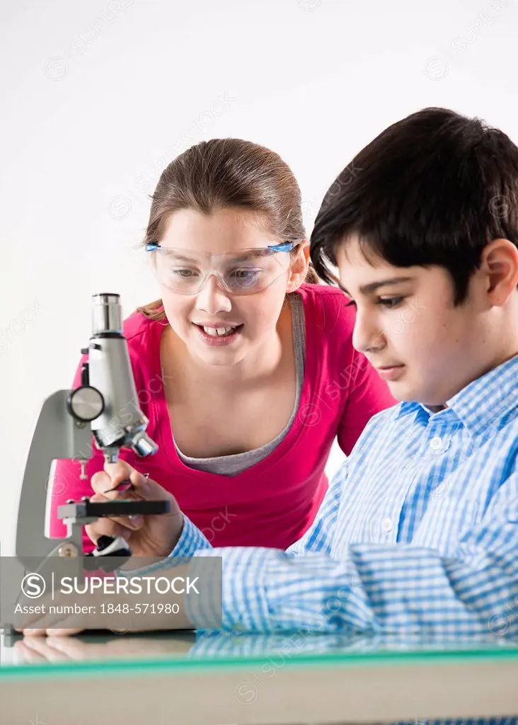 Boy and girl in front of a microscope
