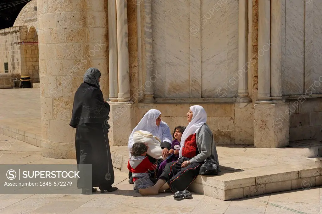 Israeli Palestinian women wearing headscarves resting with their children on the base of the Ascension Church, Temple Mount, Muslim Quarter, Old City,...