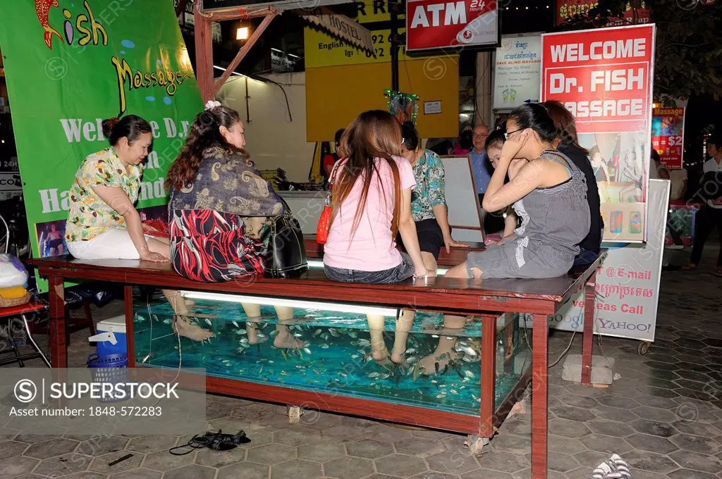 Khmer women getting a foot massage from doctor fish at the roadside, Siem Reap, Cambodia, Southeast Asia, Asia