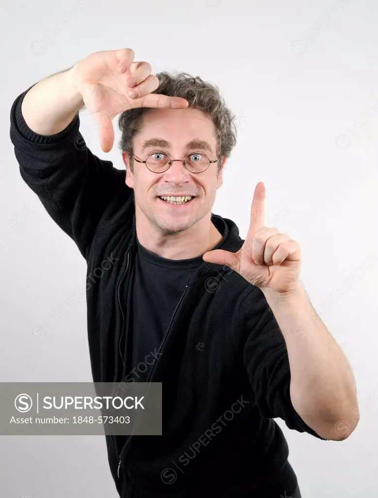 Young man with glasses make a frame with his hands