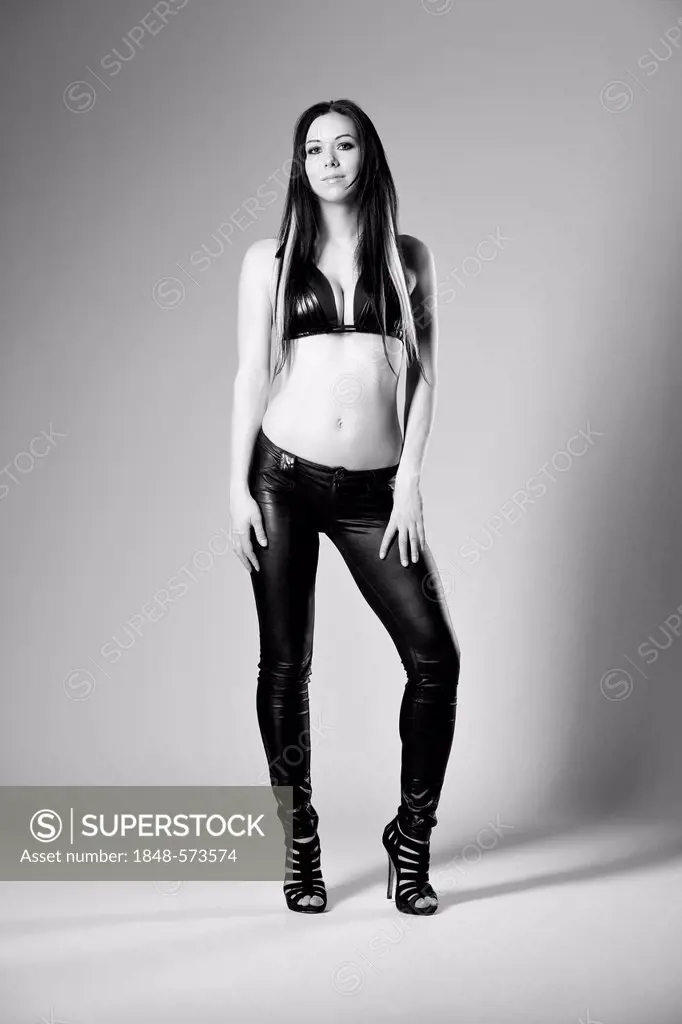 Woman in a bikini top, black pants and high heels