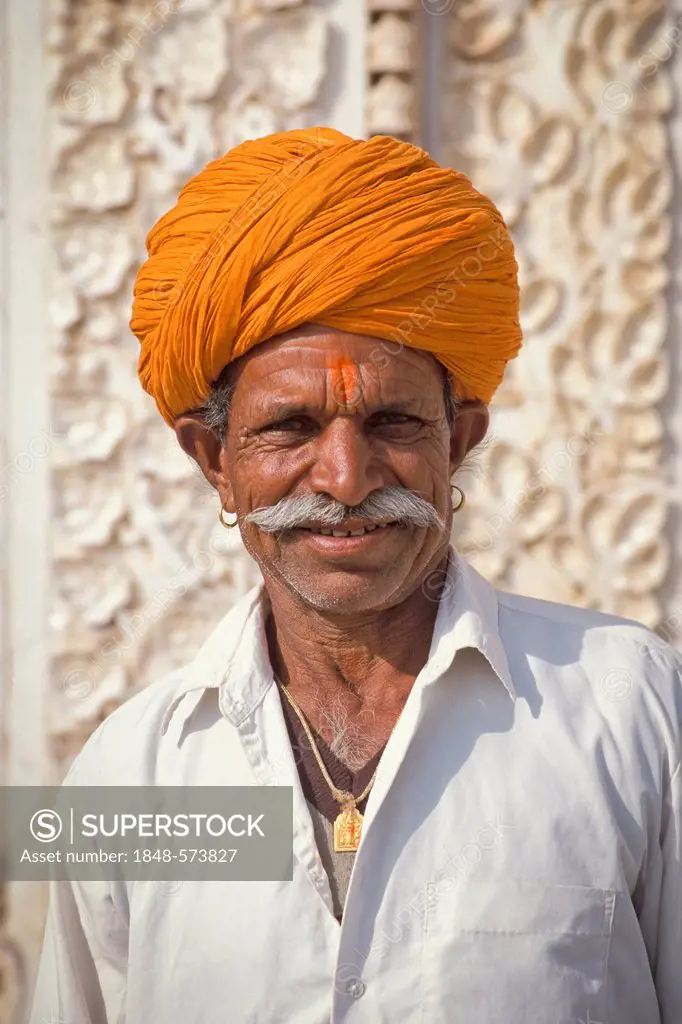 Portrait of a man with an orange-coloured turban, Hindu, in front of the marble facade of the Karni Mata Temple, Rat Temple, Deshnook or Deshnok, Raja...