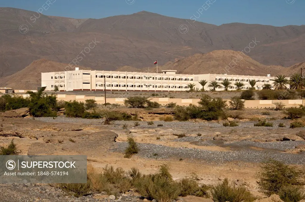 Modern school buildings in the barren landscape at the foot of the Hajar Mountains on the outskirts of Nizwa, Sultanate of Oman, Middle East, Asia