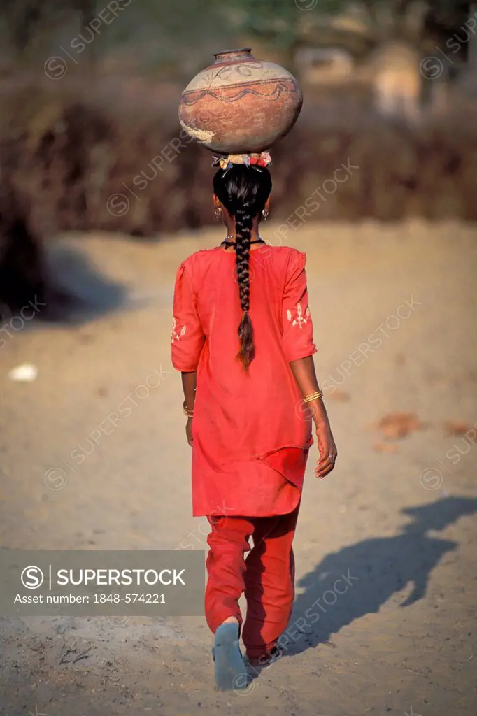 Girl carrying a jar on her head, village of Katariyasar near Bikaner, Rajasthan, Thar Desert, North India, India, Asia