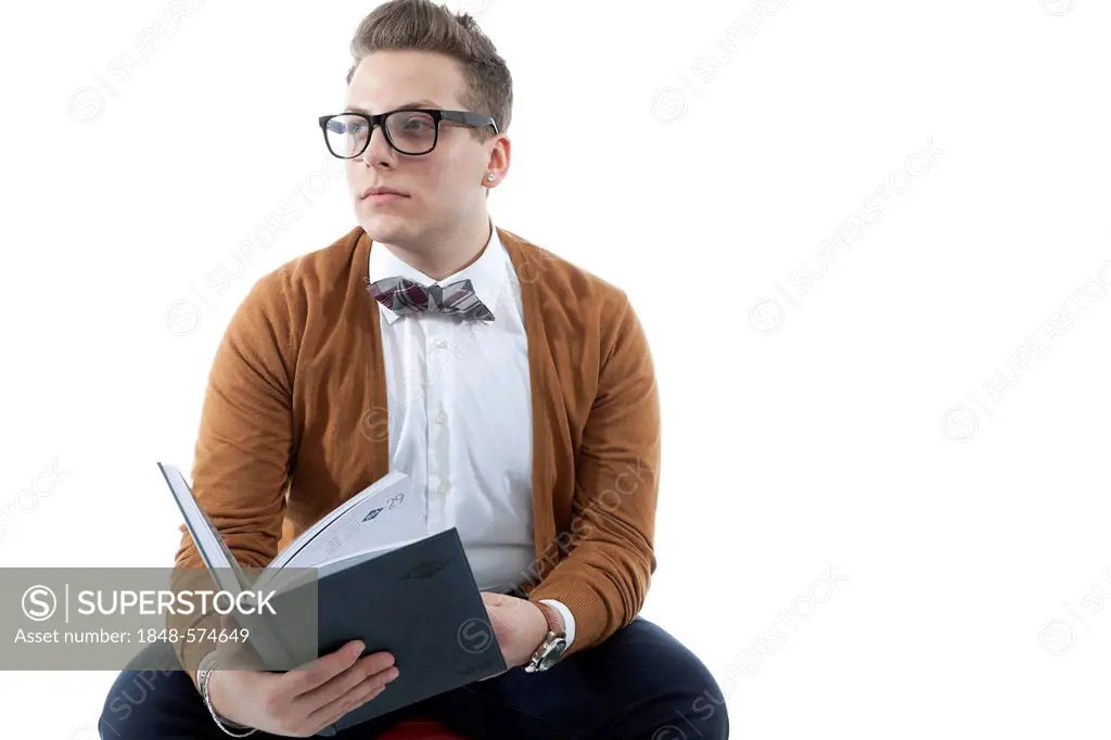 Young man with glasses and a bow tie leafing through a book, diary