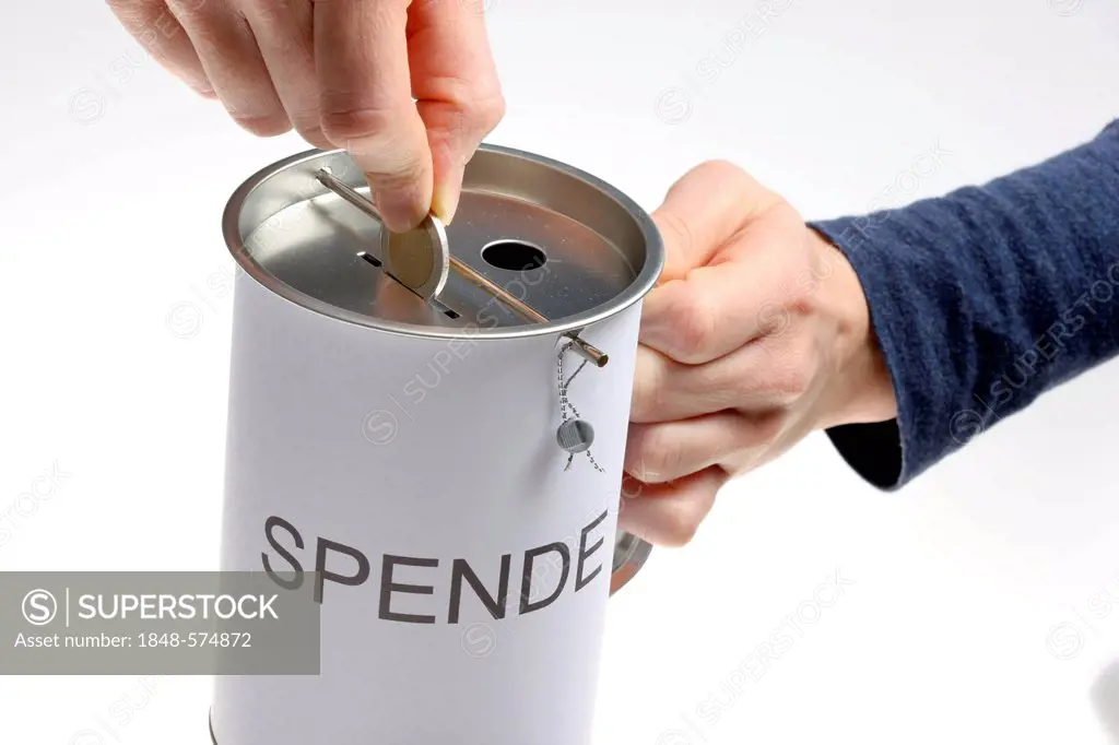 Hands with a donation box labeled Spende, German for donation, with slots for coins and bills, with a security seal to protect against unlawful openin...