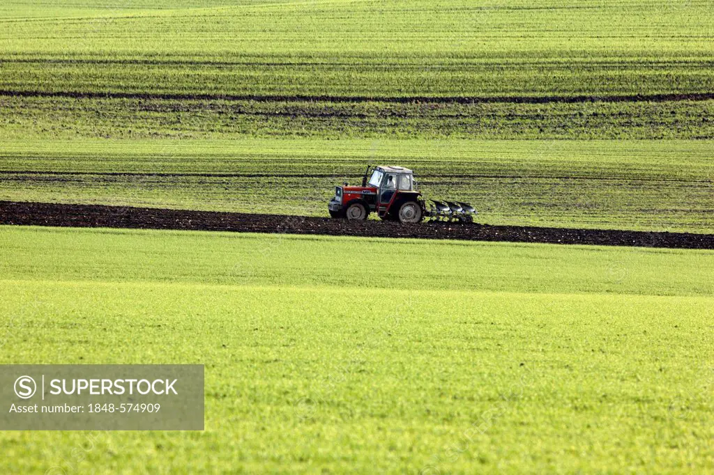 Tractor harrowing a field, preparing the soil for the sowing of new crops, Eschweiler, North Rhine-Westphalia, Germany, Europe