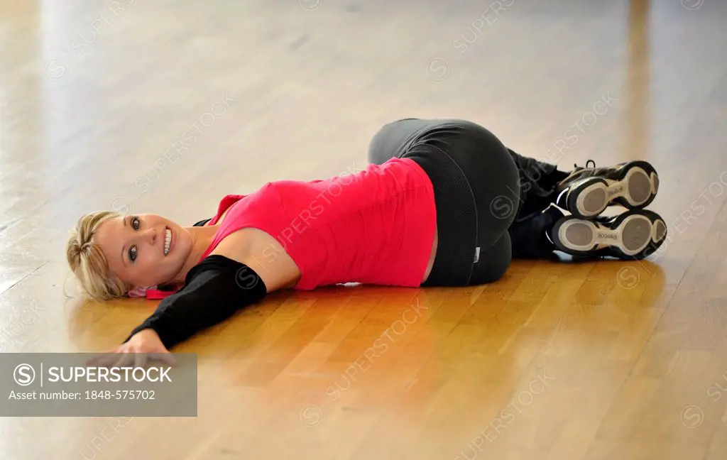 Young woman stretching, warming up exercises, Haus des Sports, House of Sport, SpOrt, Stuttgart, Baden-Wuerttemberg, Germany, Europe