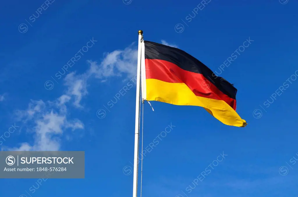 German flag flying against a blue sky with clouds, Germany, Europe