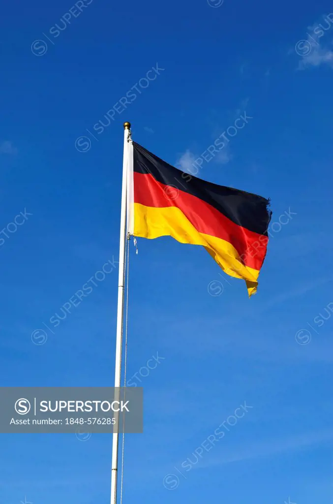 German flag flying against a blue sky with clouds, Germany, Europe