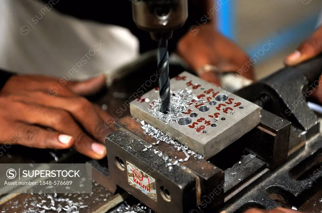 Vocational training as a metalworker, vocational student drilling different size holes in a steel ingot, Youhanabad, Lahore, Punjab, Pakistan, Asia