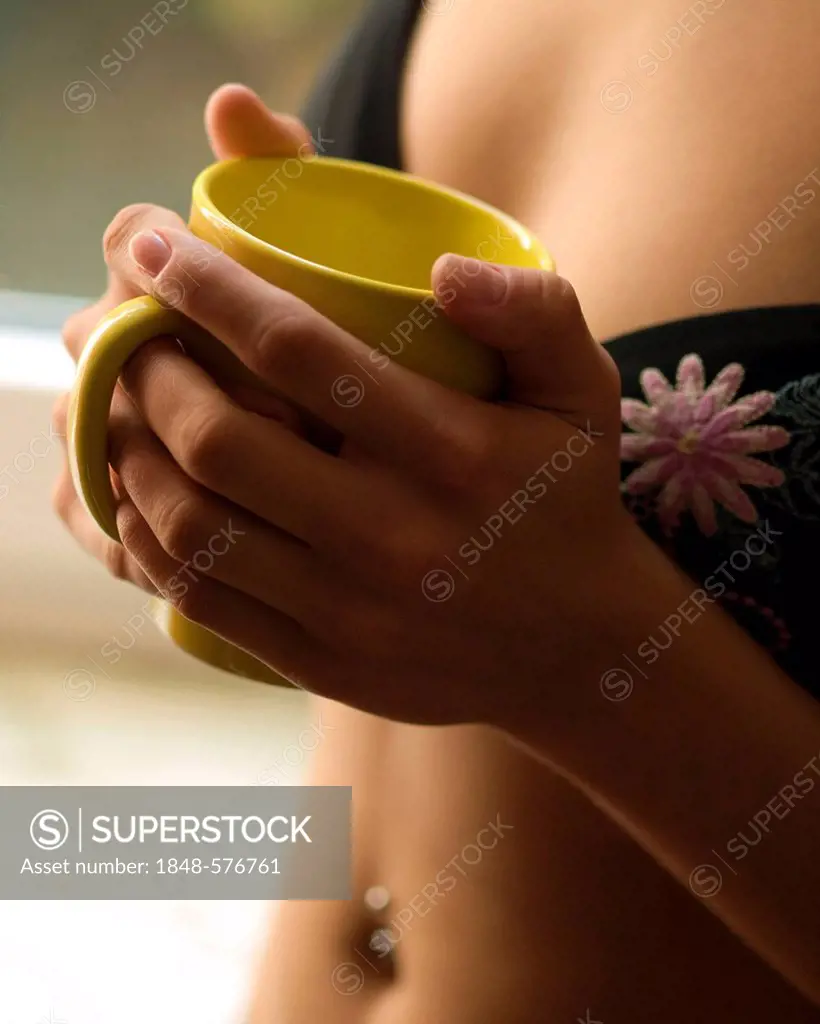 Woman hodling a coffee cup, bra