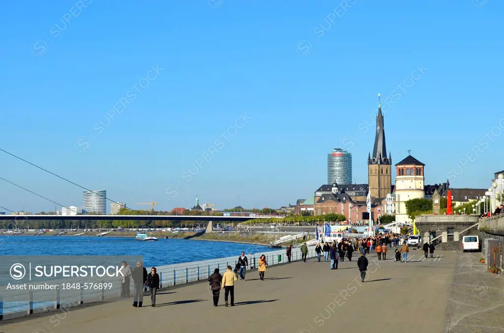 Rheinuferpromenade, Rhine promenade, ramblers walking along the Rhine, historic town and Oberkasseler Bruecke bridge at back, Duesseldorf, Rhineland, ...
