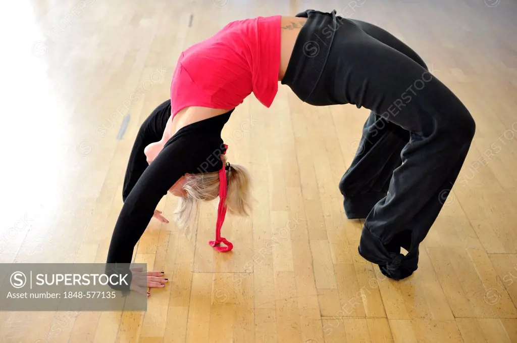 Young woman stretching, warming up exercises, bridge, Haus des Sports, House of Sport, SpOrt, Stuttgart, Baden-Wuerttemberg, Germany, Europe