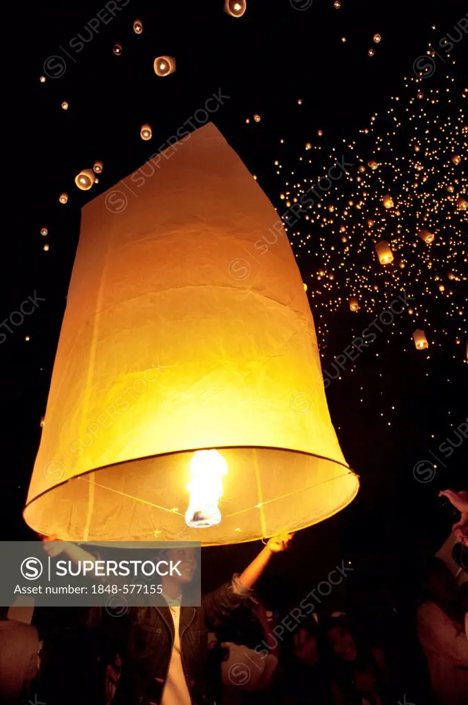 People holding the traditional fire lanterns before releasing them into the night sky during the Yeepeng festival, also referred to as Loi Krathong, i...