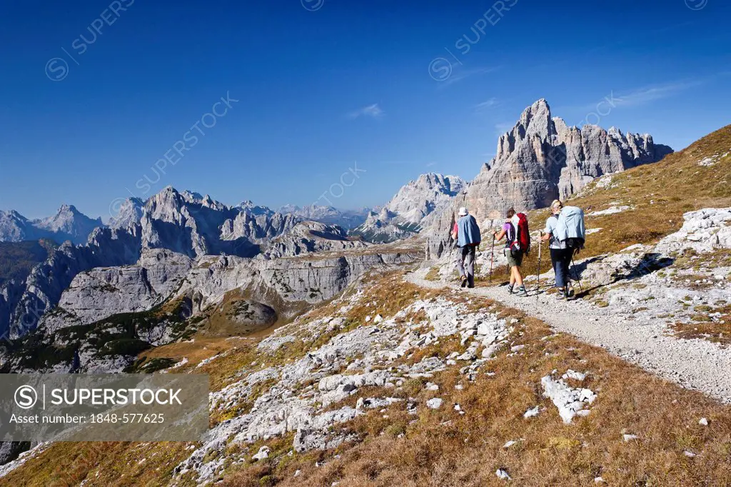 Hikers at the Pian di Cengia ridge, climbing Mt Paterno, Tre Cime di Lavaredo massif, the Cadini di Misurina mountain group and Mt Monte Cristallo in ...