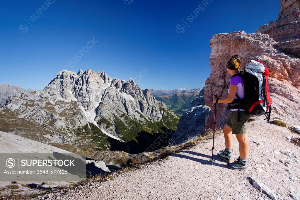 Hikers below the Pian di Cengia ridge, climbing Mt Paterno, Mt Punta dei Tre Scarperi in the back, Val Sassovecchio Valley below, Sesto, Sexten, Alta ...