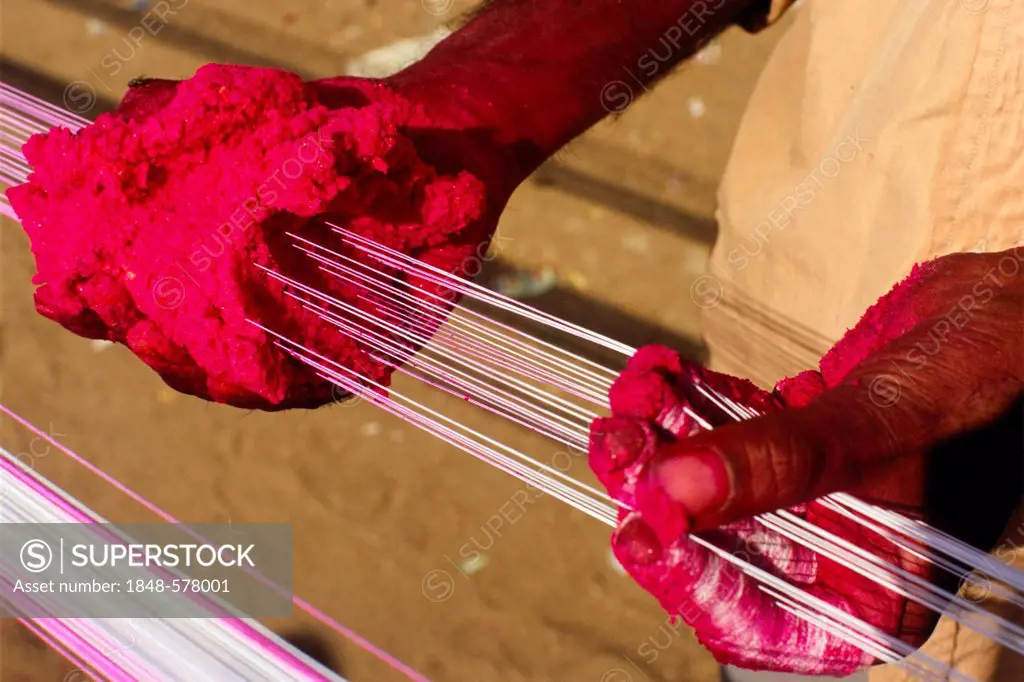 Preparing the kite threads with color and glass powder to cut the other kites off the sky, preparations for the annual kite festival in Ahmedabad, Guj...