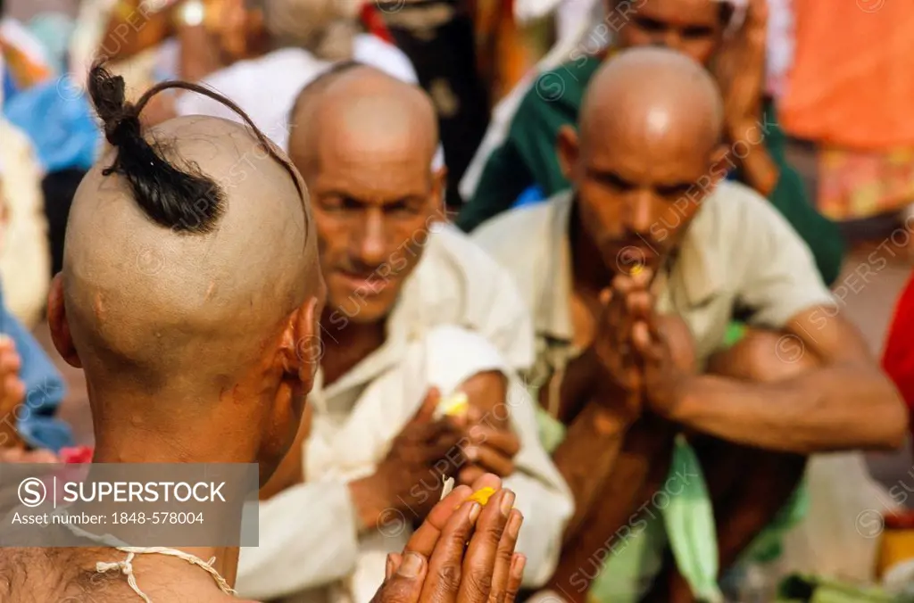 A priest is supporting a praying ritual for the good reincarnation of a dead person at Har Ki Pauri Ghat in Haridwar, Uttarakhand, formerly Uttarancha...