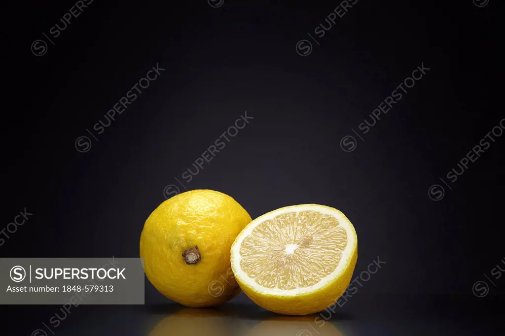 Lemon (Citrus limon) on a dark glass surface