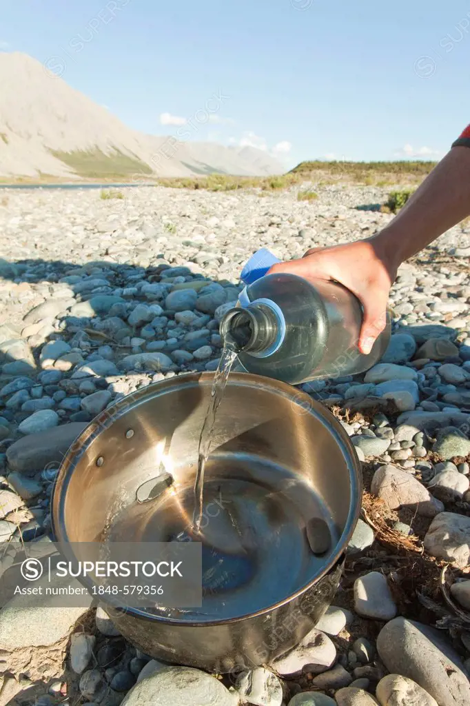 Backing bread on a camp fire, covering the pebbles in the larger pot with water, grill, camping, Wind River, Yukon Territory, Canada, captions of seri...