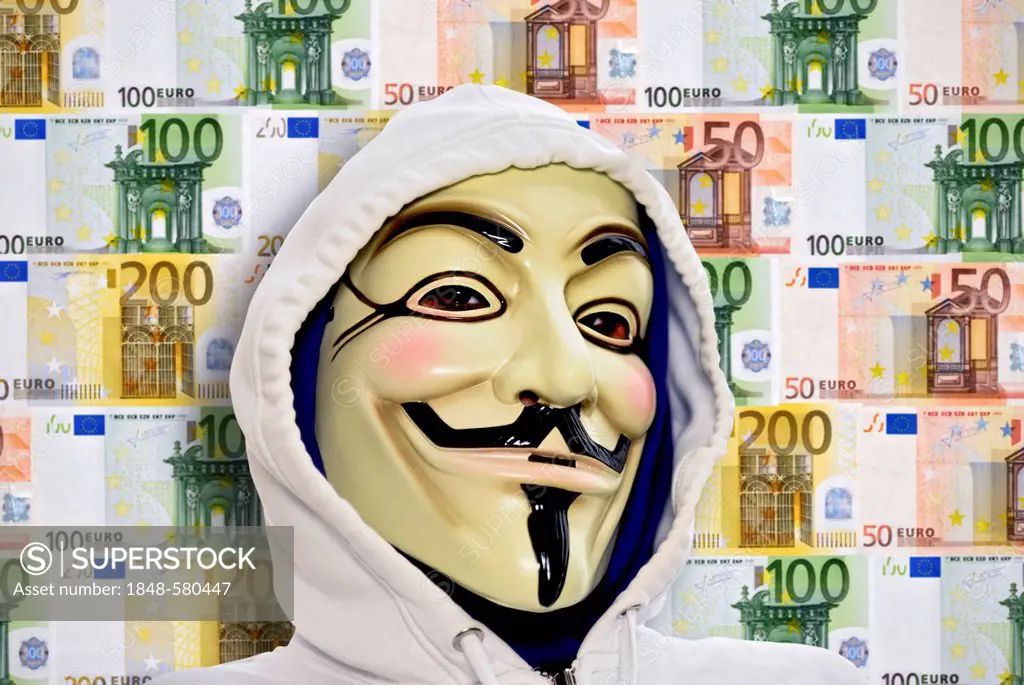 Man wearing the Guy Fawkes mask used by the Occupy movement in front of a wall of euro banknotes, protesting against the power of banks