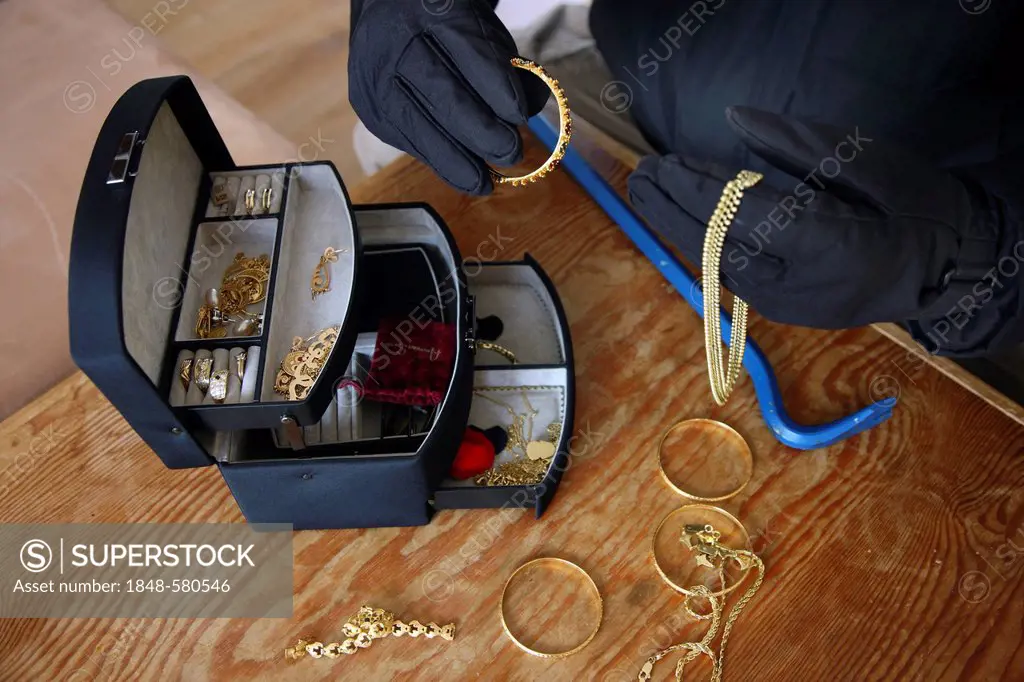 Burglar with a jewelry box, symbolic image for domestic burglary