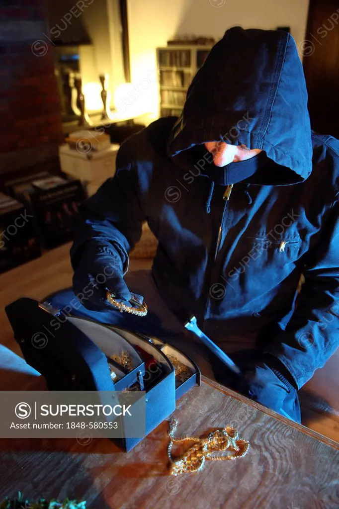 Burglar looting jewelry box, symbolic image for domestic burglary