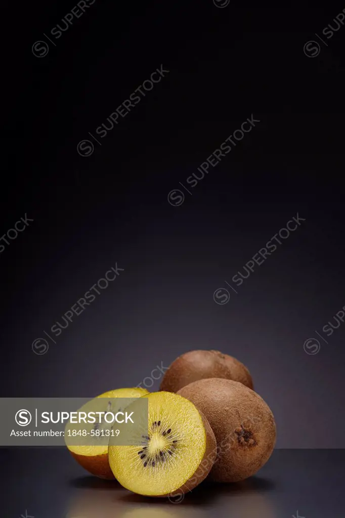 Kiwifruit (Actinidia deliciosa) on a dark glass surface