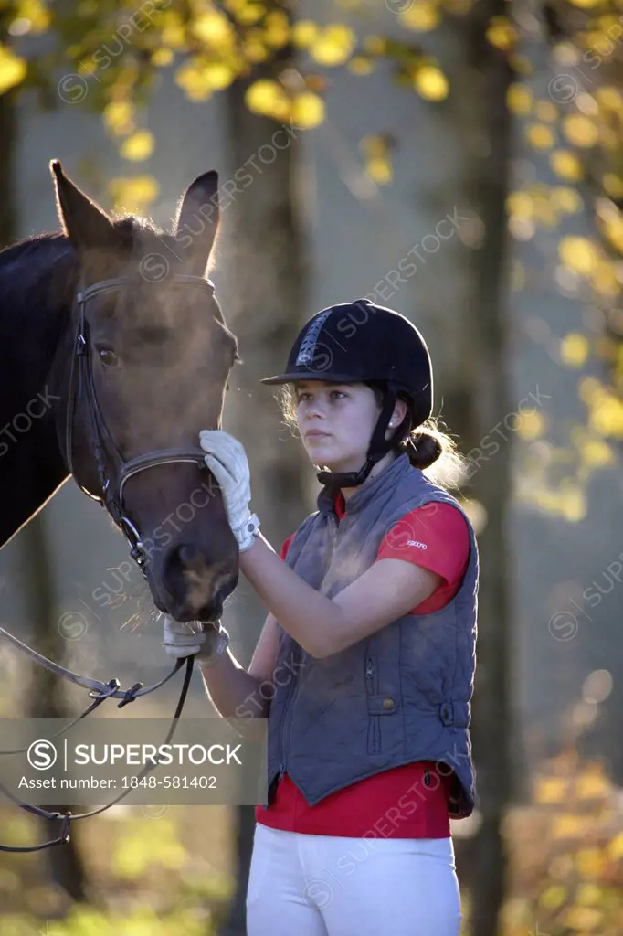 Young girl, 17 years, with her horse, in autumn