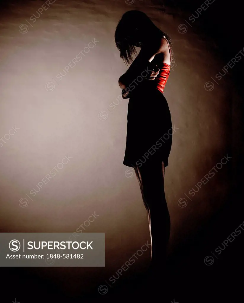 Pensive or sad woman, backlit