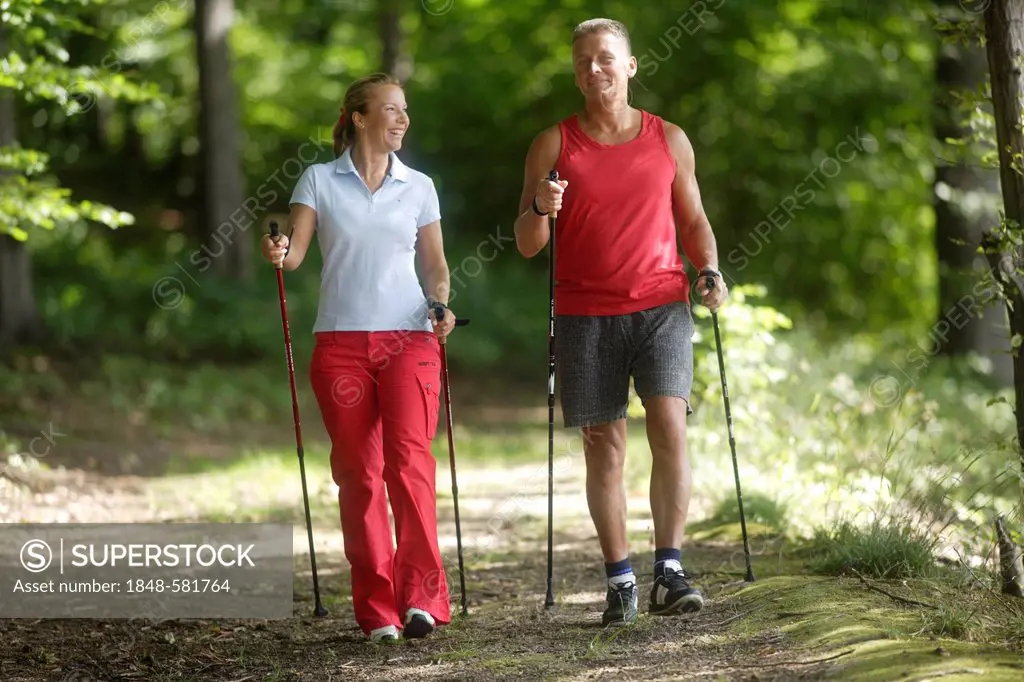 Woman, 42, and man, 52, doing Nordic Walking