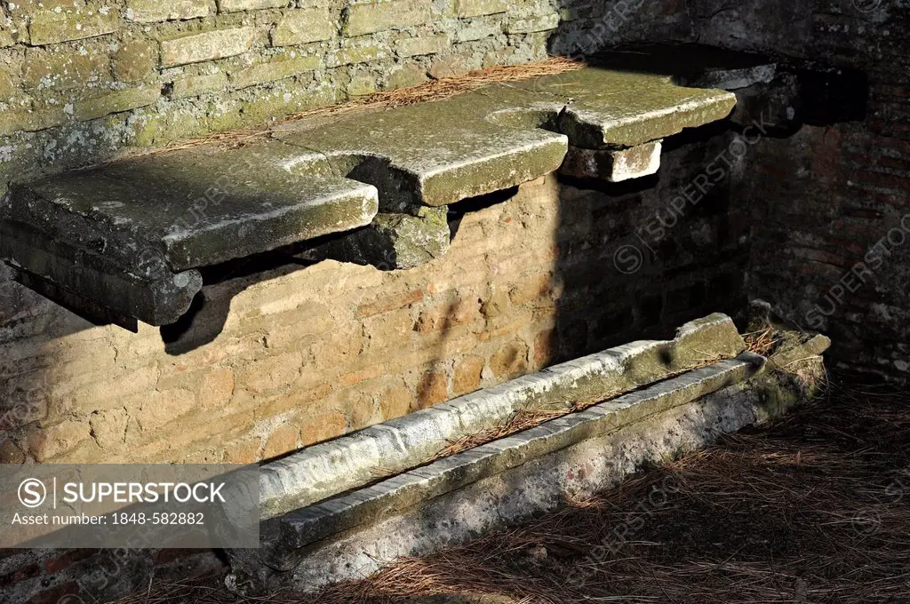 Toilet seats with a trough in a public latrine, Ostia Antica archaeological site, ancient port city of Rome, Lazio, Italy, Europe