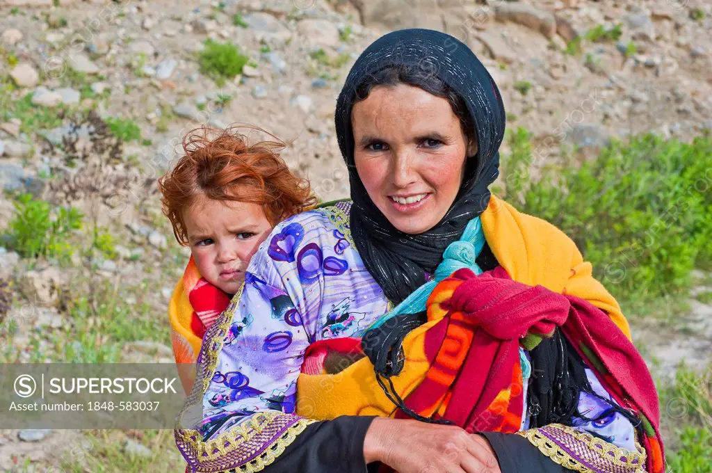 Young woman carrying a toddler in a baby sling, High Atlas, Morocco, Africa