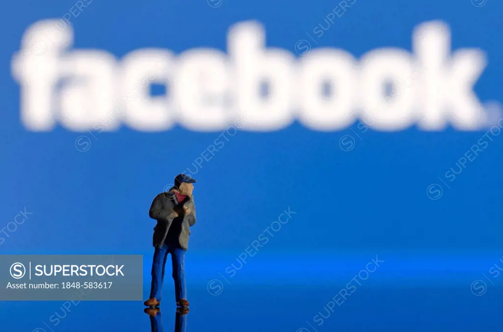 Thief, miniature figure standing in front of a blurred Facebook logo, symbolic image