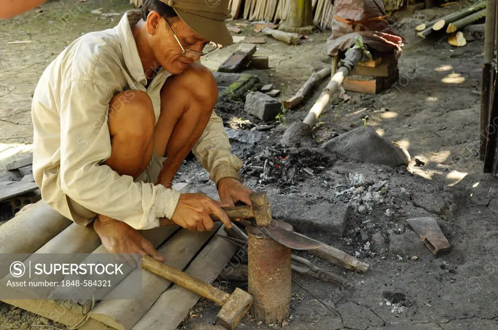 Man forging knives, Can Tho, Mekong Delta, Vietnam, Southeast Asia, Asia