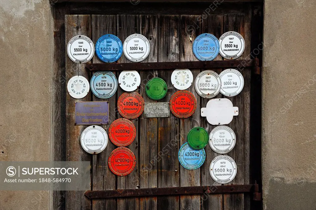 Award plaques on a barn door for the annual milk yield of cows, Wildenfels, Upper Franconia, Germany, Europe